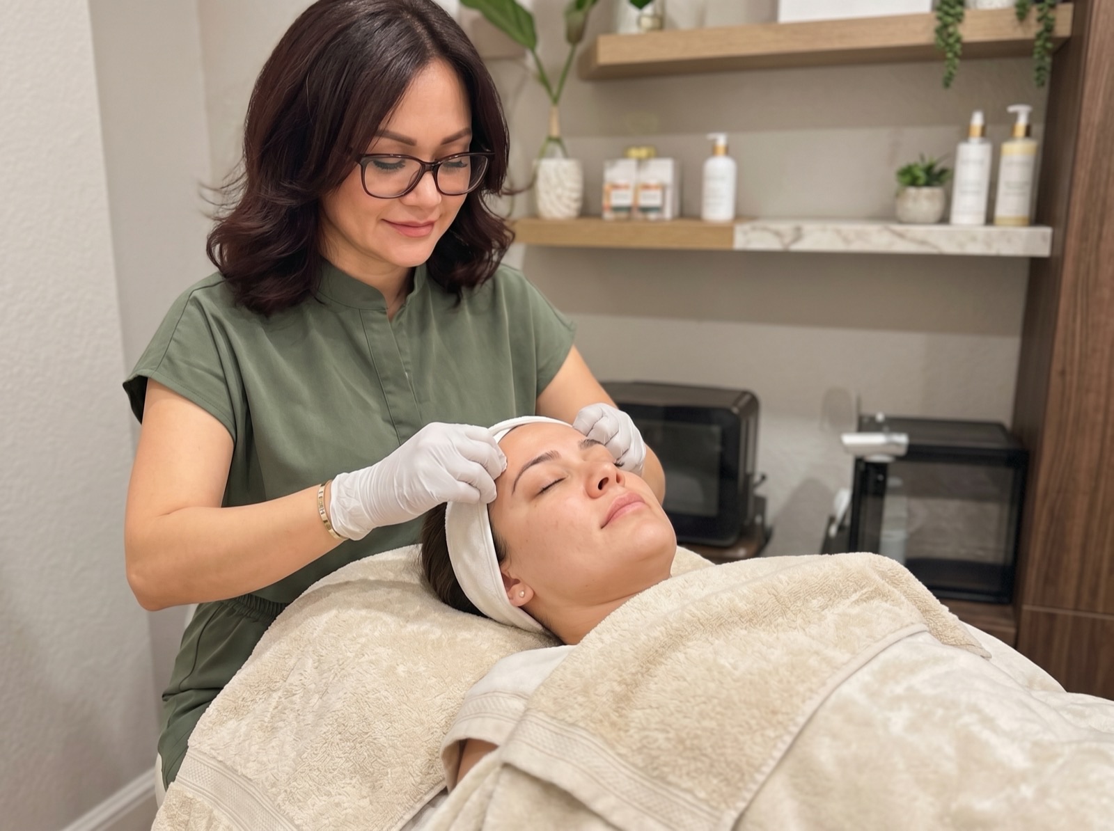 Corey performing a customized facial on a client in the treatment room